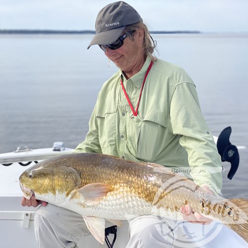 Mr Jim admiring the first of many trophy redfish he caught in two days fishing with me.