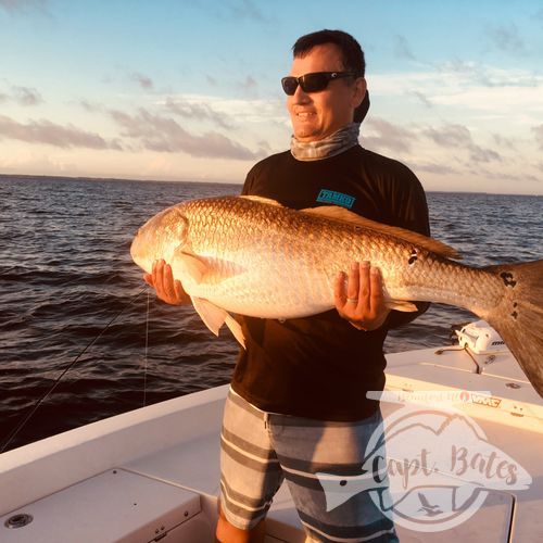 Beautiful evening citation trophy red drum as the sun sets in the background on the lower Neuse River.